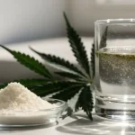White THC Powder and Cannabis Leaf with a Glass of Water