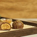 Close-up of cannabis chocolate truffles with rich peanut butter filling on a wooden tray