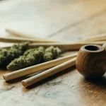 Cannabis Buds with a Wooden Smoking Pipe and Rolling Papers