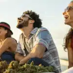 Realistic image of friends enjoying best strains for laughing, showing vibrant smiles and relaxed outdoor ambiance.