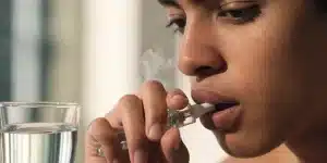 Person Using a Cannabis Vape Pen Close-Up