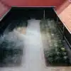 Aerial view of a cannabis plantation with mist and red-roofed buildings.