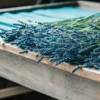 Close-up of freshly harvested blue lavender flowers on a wooden table.