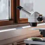 Close-up of a laboratory microscope analyzing a cannabis sample under natural light.