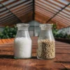 cannabis nutrient salts and pellets stored in transparent glass jars inside a greenhouse