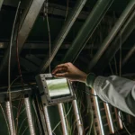 Scientist adjusting spectral lighting system for indoor plant growth.