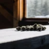 dried cannabis buds on wooden table near window light