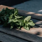 Fresh mint leaves arranged on a rustic wooden table under soft natural light.