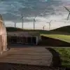 Modern renewable energy facility surrounded by wind turbines on green hills