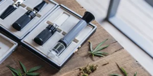 Cannabis refractometer kit displayed on a wooden table with cannabis leaves and buds