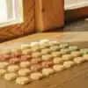 Assorted flower-shaped THC gummies arranged neatly on a wooden table near a sunlit window.