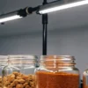 Cannabis extracts stored in glass jars on a laboratory shelf under fluorescent lighting in a controlled environment.
