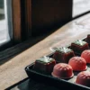 Close-up of cannabis-infused molded chocolate edibles arranged in a tray near a window with natural sunlight.