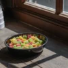 Colorful THC-infused gummies served in a small bowl on a wooden surface near a window