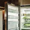 Cannabis leaves drying inside an open refrigerator used as a controlled environment for cold curing and preservation.