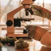 Scientist analyzing cannabis sample under microscope in a laboratory with glassware.