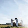 Agriculture team applying soil treatment in outdoor field with spraying equipment.