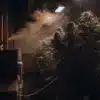 Indoor cannabis grow room with dense flowering plants and vapor monitoring during controlled cultivation.