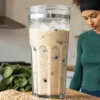 Healthy hemp protein smoothie with spinach, berries, and seeds in a blender cup.