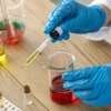 Scientist using a dropper to transfer liquid samples in a chemistry laboratory.
