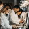 Laboratory technicians performing cannabis sample analysis on computer systems.