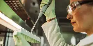 Scientist using pipette for cannabis sample testing in modern laboratory.