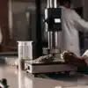Cannabis density testing laboratory with technicians analyzing flower samples using precision equipment.
