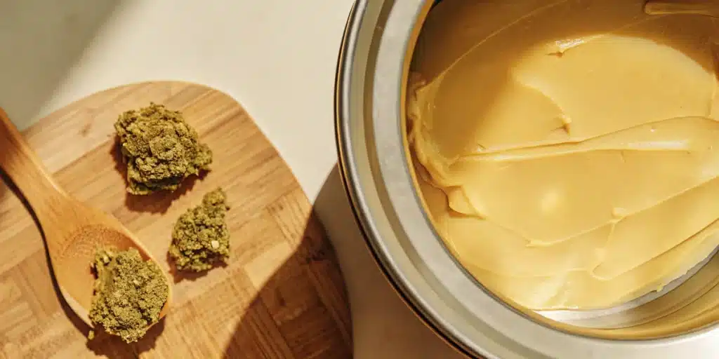 Cannabis flower and infused butter prepared for homemade cannabis butter production in a kitchen setting.