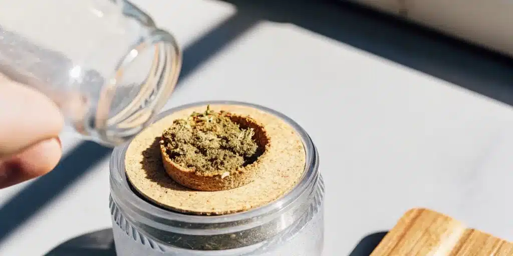 Cannabis shake being transferred into an airtight storage jar.